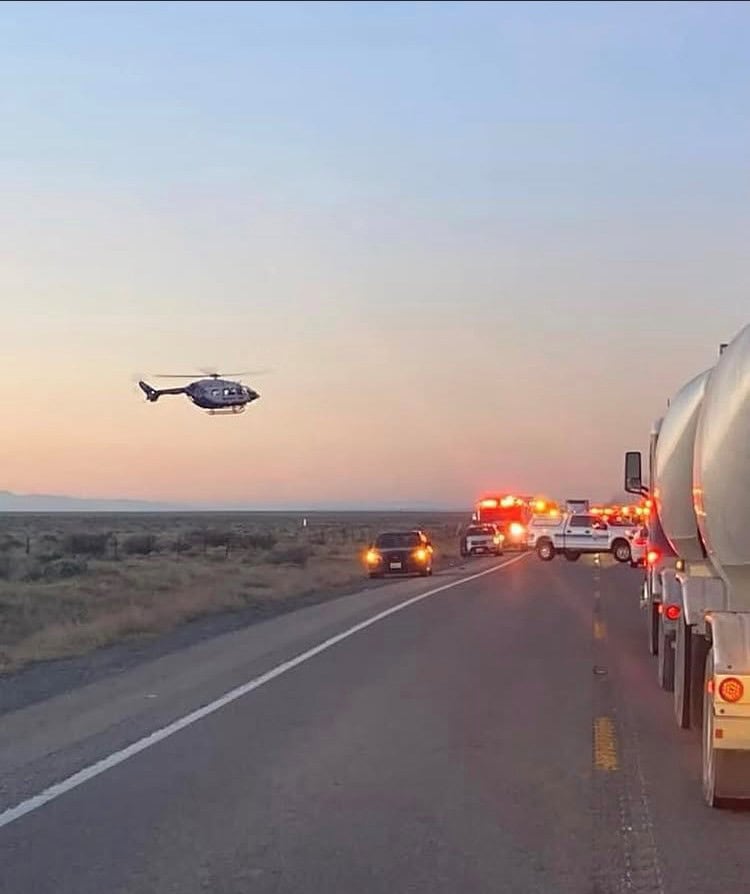 Emergency response scene with police, fire trucks, and a helicopter on a highway at sunset, related to Searle Starter incident, home page context.