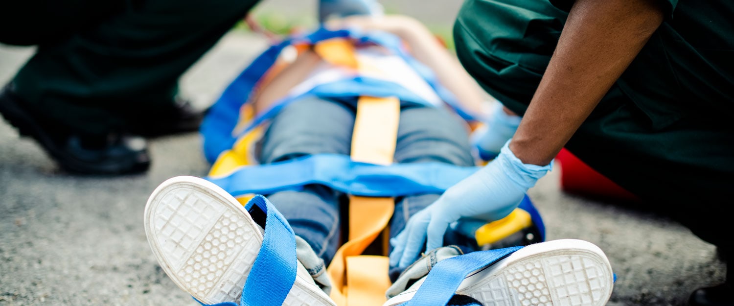 An emergency medical responder prepares to assist a patient with a Searle Starter kit, emphasizing quick response and first aid readiness for home or outdoor emergencies.