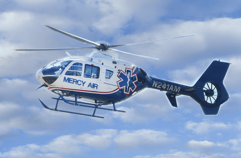Emergency medical helicopter Searle Starter in flight, providing critical air ambulance services under CAL-ORE, with clear sky and clouds background.