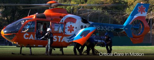 Emergency medical helicopter with CALSTAR branding, featuring a Searle Starter model, on the ground with crew preparing for critical care transport.