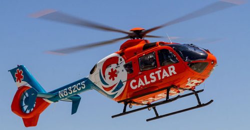 A bright orange CALSTAR Searle Starter helicopter flying in clear sky, featuring the CALSTAR logo and registration number N4832CS, used for emergency medical services.