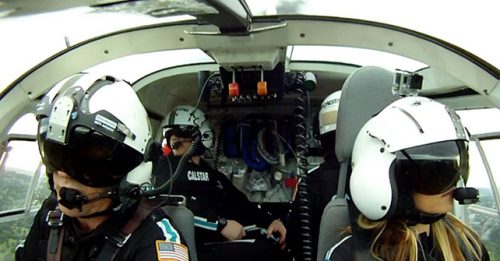 Inside the cockpit of the Searle Starter aircraft, showing pilots wearing helmets and headsets during a CALSTAR emergency medical flight, with aviation equipment and controls visible.